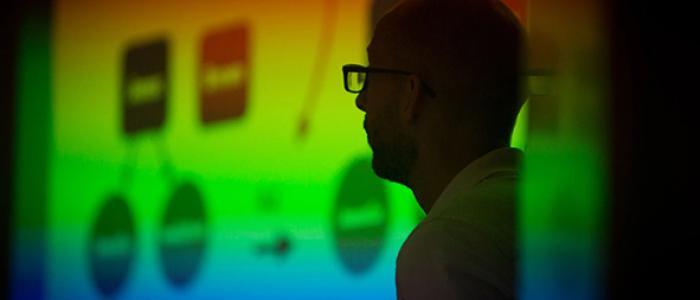 Silhouetted instructor in front of a colorful projected presentation slide.